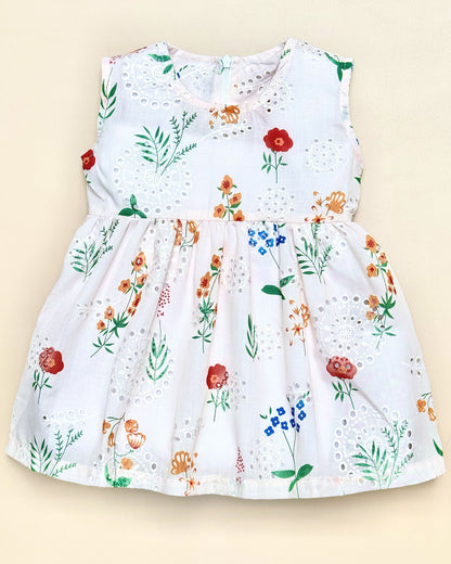 White dress with colorful floral pattern on a beige background