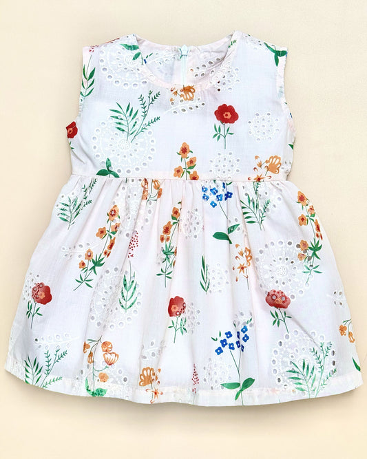 White dress with colorful floral pattern on a beige background