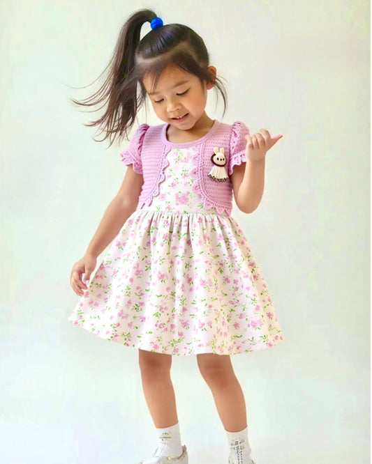 Young girl wearing a pink floral dress with a white background